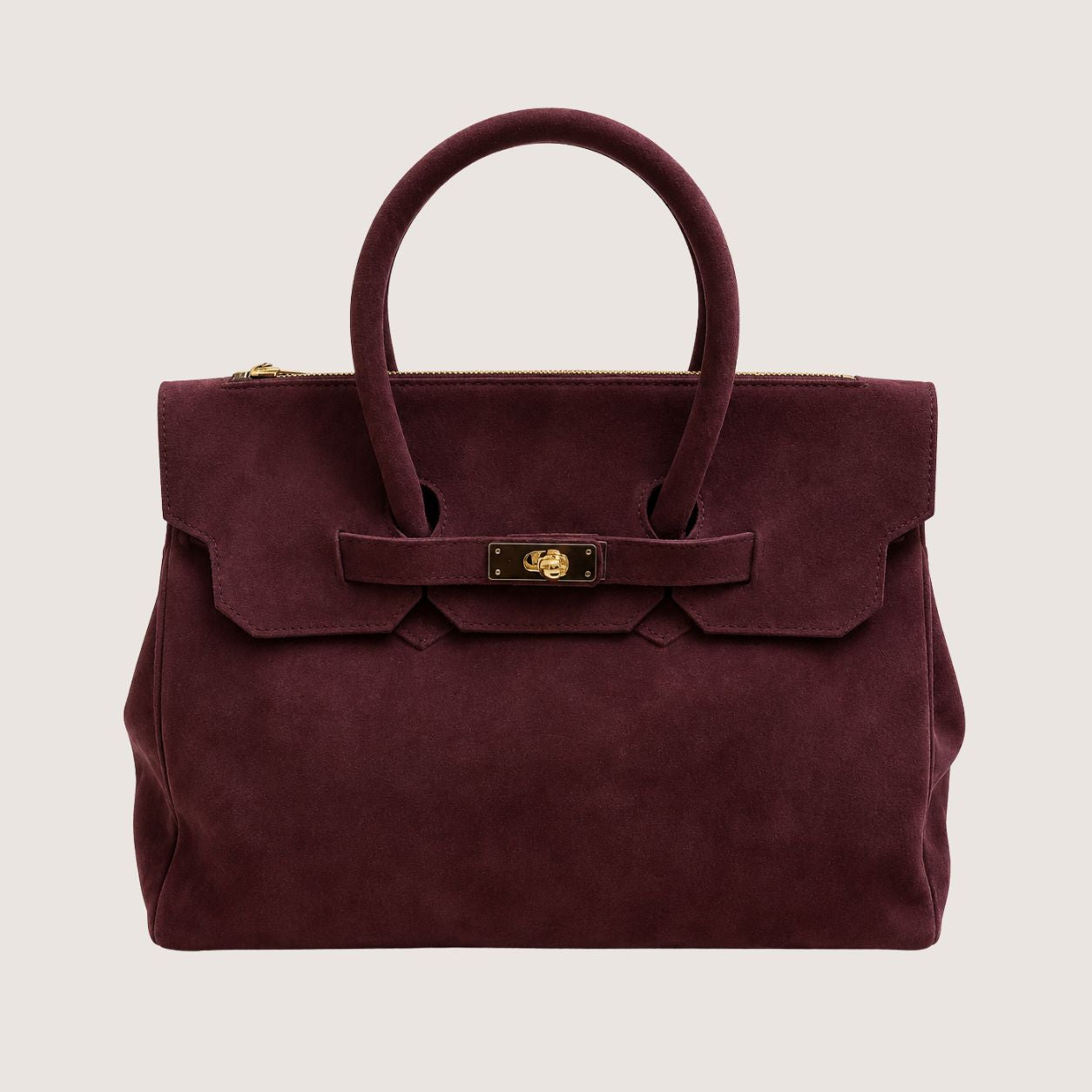 Deep burgundy suede handbag with a gold clasp on a light beige background.