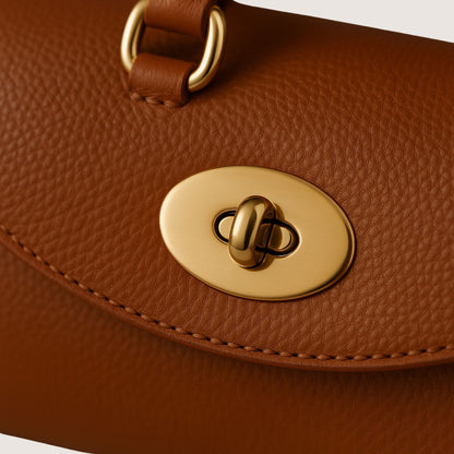 Close-up of the Florence bag’s light-gold turn-lock hardware and Cuoio Soft Togo leather texture in a warm caramel-brown tone.