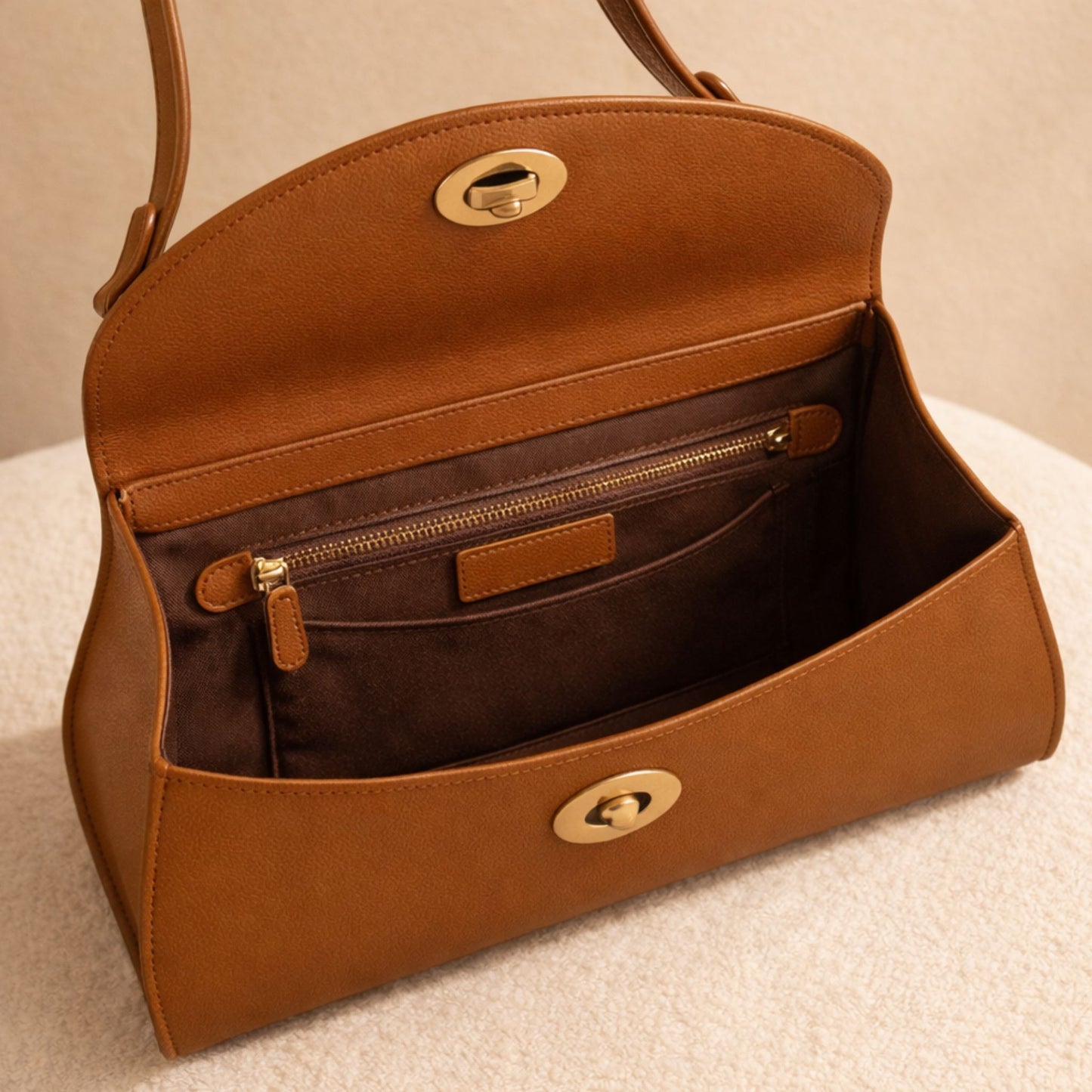 Interior view of the Florence bag showing the microsuede lining, zip pocket, and Cuoio Soft Togo leather in a warm caramel-brown tone.