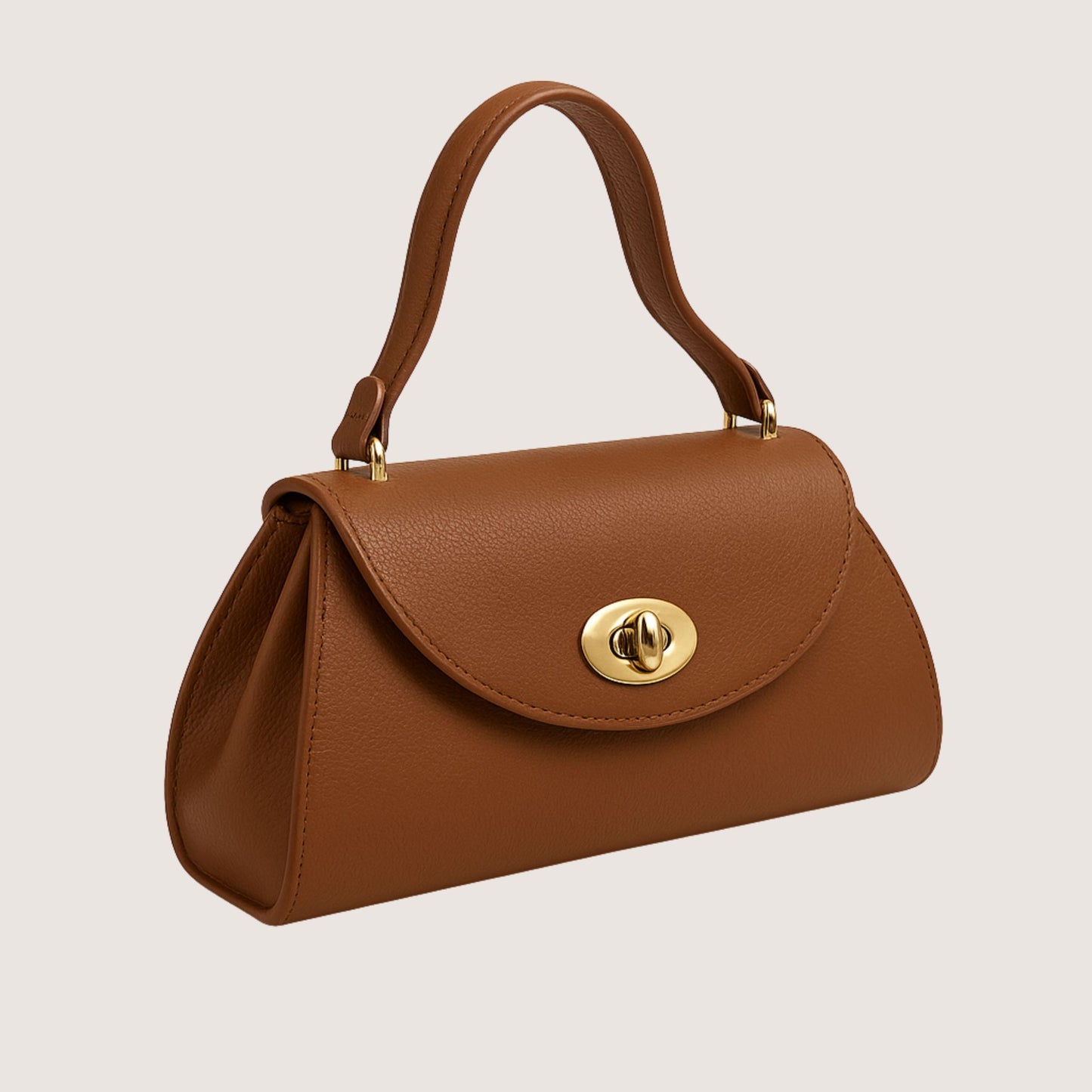 Florence top-handle bag in Cuoio Soft Togo leather, warm caramel-brown hue, shown from a side angle to highlight the sculptural silhouette.